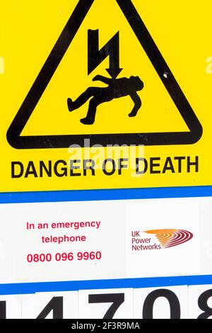 Nahaufnahme eines grafischen Warnschilds mit der Aufschrift „Danger of Death“ am Tor eines Umspannwerks in London, Großbritannien Stockfoto