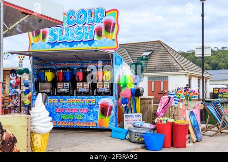 Ein Stall, der eiskalten Slush an der Küste serviert, sowie Fischernetze und andere Strandspielzeug, Westward Ho!, Devon, UK Stockfoto