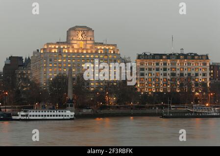 Themse mit Lastkähnen, am frühen Abend beleuchtete Fenster im Savoy Hotel, Shell Mex House, London Stockfoto