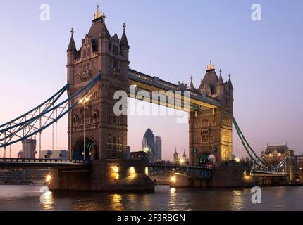 Blick über die Themse mit erleuchteter Tower Bridge und 30 St Mary Axe (ehemals Swiss Re Building und informell auch als Gherkin bekannt) Stockfoto