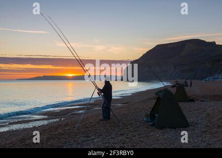 Seatown, Dorset, Großbritannien. 17th. März 2021. Wetter in Großbritannien. Fischer genießen die Meeresluft am Strand bei Sonnenuntergang in Seatown in Dorset, während der Himmel nach einem bewölkten Nachmittag während der Covid-19-Sperre aufklärt. Bild: Graham Hunt/Alamy Live News Stockfoto