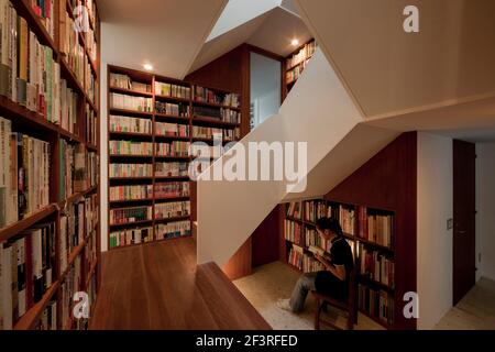 Haus in Musashiseki, Privathaus, Blick auf die Treppe, positioniert in der Mitte des Hauses, umgeben von Bücherregalen. Stockfoto