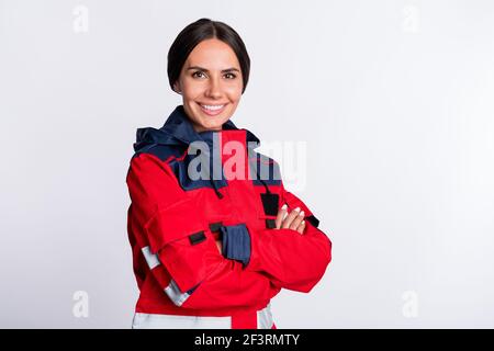 Foto von positiven charmante junge Dame Sanitäter gekleidet rote Uniform Lächelnde Hände gefaltet isoliert weißen Hintergrund Stockfoto