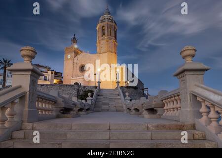 Beleuchtete Kirche in Sitges, Katalonien, Spanien mit wolkenblauem Himmel am Abend Stockfoto