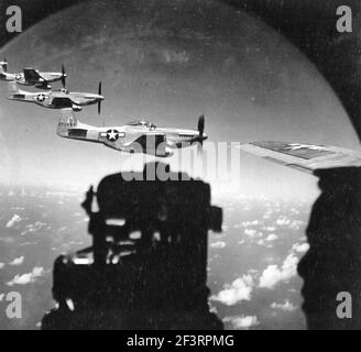 Waist Gunner von Escort B-29 Superfortress Uhren EIN Trio von North American P-51 Mustangs Flying Close-in während EINES Fighter Sweep Nach Japan Stockfoto