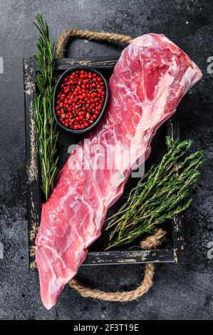 Rohes Kalbskalb kurzes Rippenfleisch mit Thymian und Rosmarin. Schwarzer Hintergrund. Draufsicht Stockfoto