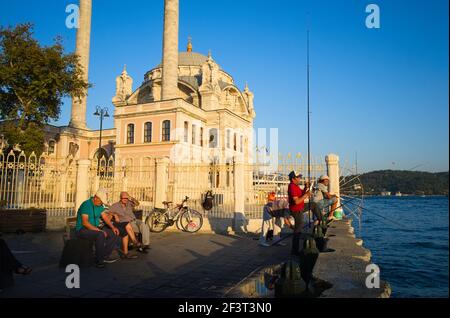 Istanbul, Türkei - September, 2018: Fischer fischen in der Nähe der Ortaköy Moschee am Ufer des Ortakoy Pier. Stockfoto