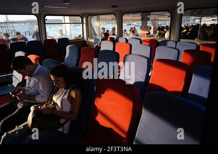 Istanbul, Türkei - September, 2018: Passagierfahrt mit der Fähre von Eminonu nach Kadikoy. Abend Sonnenuntergang Licht beleuchtet weichen Stühlen auf dem Boot. Stockfoto