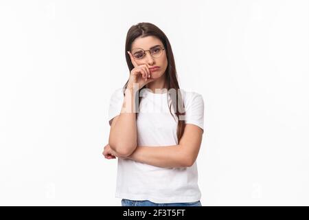 Waist-up-Porträt von gelangweilten, uninteressierten jungen Brünette Frau in Brille, fühlen sich müde oder schläfrig, hören zu langweiligen Gespräch, lehnen Sie sich auf die Hand schauen Stockfoto