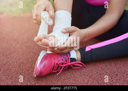Afro American girl Putting Verband auf verletzten Fuß Stockfoto
