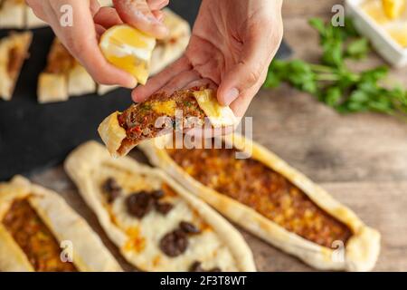 Kasarli suculu Pide und Kiymali Pide sind traditionelle türkische Fladenbrote, ähnlich wie Pizza mit Fleisch- und Käsezulagen. Sie werden mit Zitrone und serviert Stockfoto