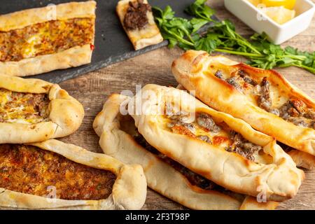 Kasarli suculu Pide und Kiymali Pide sind traditionelle türkische Fladenbrote, ähnlich wie Pizza mit Fleisch- und Käsezulagen. Sie werden mit Zitrone und serviert Stockfoto