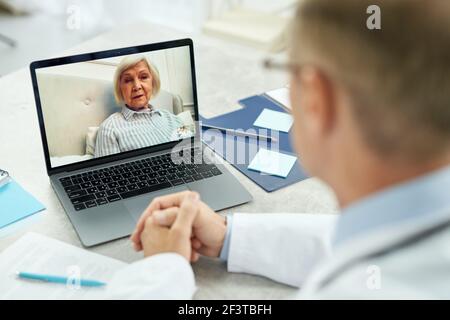 Nette alte Frau mit Online-Beratung mit Arzt Stockfoto