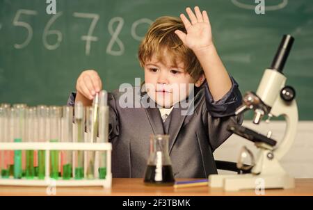 Kind studiert Biologie und Chemie in der Schule. Schulbildung. Erforschen Sie biologische Moleküle. Kleinkind Genie Baby. Boy in der Nähe von Mikroskop und Reagenzgläsern Stockfoto