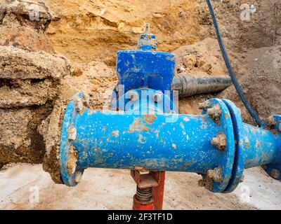 Große unterirdische Rohre und Ventile. Lange Wasserlinie bergab vom Wasserspeicher zur Stadt in der Ferne. Stockfoto