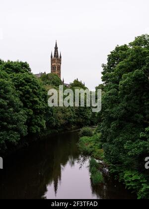 Die University of Glasgow steht über den Bäumen, die den Fluss Kelvin säumen, und den Spazierwegen durch den Kelvingrove Park. Stockfoto