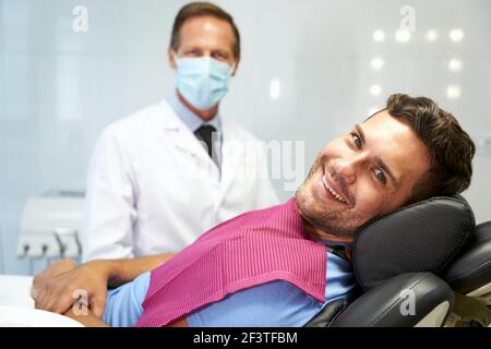 Positiver Patient und sein Arzt in der Zahnarztpraxis Stockfoto