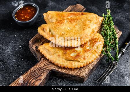 Mexikanische chilenische Lebensmittel gebratene Empanadas Pie mit Rindfleisch Fleisch. Schwarzer Hintergrund. Draufsicht Stockfoto