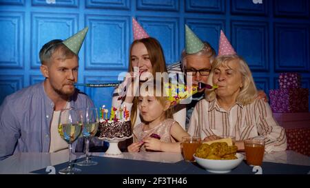 Mädchen Kind Blasen Kerzen auf Kuchen machen Wunsch, Spaß zu haben, Geburtstagsfeier mit der Familie zu feiern Stockfoto