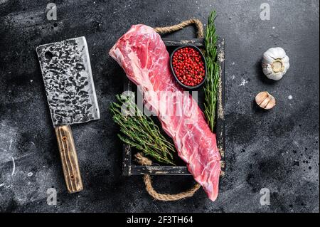 Rohes Kalbskalb kurzes Rippenfleisch mit Thymian und Rosmarin. Schwarzer Hintergrund. Draufsicht Stockfoto