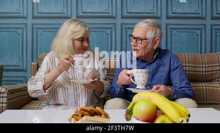 Reifes Familienpaar Großvater, Großmutter entspannen auf gemütlichen Sofa genießen Gespräch zu Hause Stockfoto