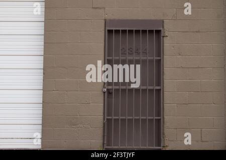 Augusta, GA USA - 03 17 21: Braune Wand mit verschlossener Eisentür Stockfoto