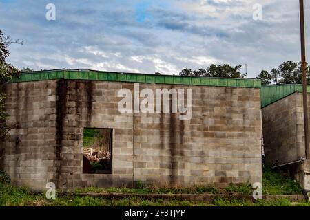 Augusta, GA USA - 03 17 21: Eine Blockwand und ein Fenster mit grünem Dach wolkigen Himmel Stockfoto