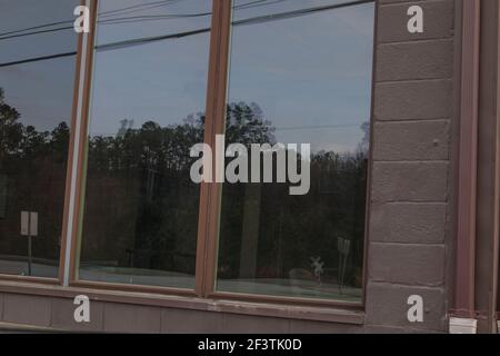 Augusta, GA USA - 03 17 21: Braune Wand Fenster und Rahmen Reflexion dunkel Stockfoto