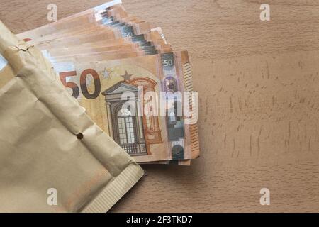 Nahaufnahme eines Umschlags mit 50 Euro Scheinen auf Ein Holztisch und Kopierer Platz Stockfoto