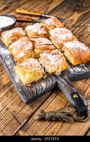 Griechisches Gebäck Bougatsa mit Phyllo-Teig und Grießpudding Sahne. Holzhintergrund. Draufsicht Stockfoto