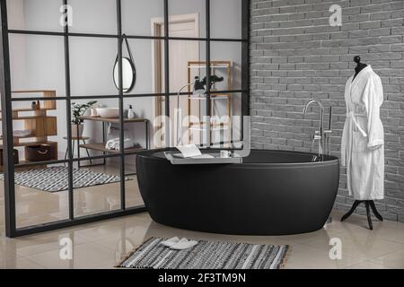 Stilvolle Einrichtung des Badezimmers mit schwarzer Badewanne Stockfoto