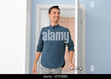 Glücklicher Mann, der zu Hause in der Tür steht Stockfoto