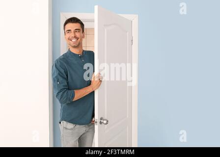 Glücklicher Mann, der zu Hause in der Tür steht Stockfoto