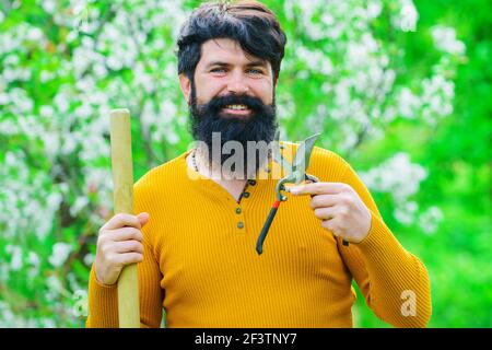 Lächelnder Mann mit Gartenschere. Gartenarbeit im Frühling. Stockfoto