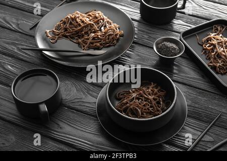 Teller mit Soba-Nudeln auf dunklem Holzhintergrund Stockfoto