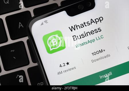 WhatsApp Business App auf dem Bildschirm auf dem Smartphone gesehen, die auf der Laptop-Tastatur platziert ist. Stafford, Großbritannien, 14. März 2021 Stockfoto