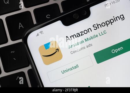 Amazon Shopping App auf dem Bildschirm auf dem Smartphone, das auf der Laptop-Tastatur platziert wird gesehen. Stafford, Großbritannien, 14. März 2021