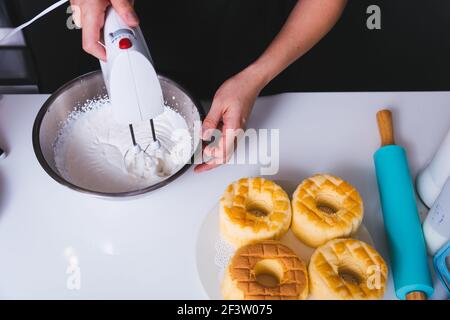 Frau schlagen Teig Mixer von Maschine in Schüssel auf sie Küche Stockfoto