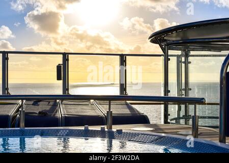 Sonnenlicht reflektiert auf dem Meer und zwei Schiffe, wie von einem Whirlpool auf dem oberen Deck eines Kreuzfahrtschiffes gesehen. Stockfoto