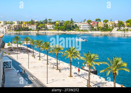 Der Hafen der Hafenstadt Brindisi, Italien, in der südlichen Region Apulien an einem sonnigen Sommertag mit Palmen säumen die Promenade. Stockfoto