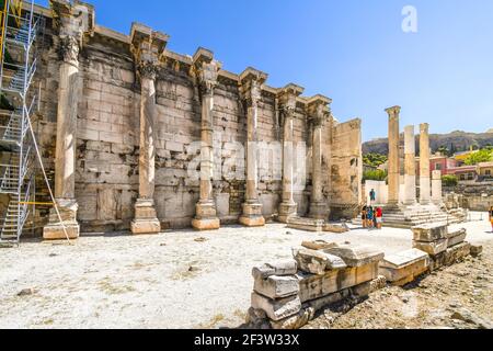 Touristen besichtigen die alte Westmauer der Hadrianbibliothek in der römischen Agora in der Nähe des Plaka-Bezirks in Athen, Griechenland. Stockfoto