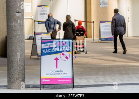 Menschen gehen in ein Metro Convention Center Impfzentrum, um ihren COVID-19-Impfstoff zu erhalten.Toronto hat ein Programm zur Bekämpfung der COVID-19-Pandemie gestartet. Stockfoto