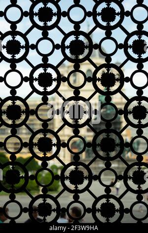 Ein Blick durch einen verzierten Metallgrill in Wien, Österreich Stockfoto