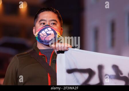 Washington, DC, USA, 17. März 2021. Im Bild: Ein Mann hält ein Ende des koreanischsprachigen Banners während eines Protestes gegen antiasiatische Gewalt nach den Morden in Georgien. Seine Maske Black Lives Matter/Pride spiegelt die Solidarität wider, die sich im vergangenen Jahr in der Gemeinschaft der sozialen Gerechtigkeit in DC einsetzte. Kredit: Allison C Bailey/Alamy Live Nachrichten Stockfoto