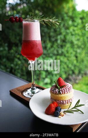 Erdbeer-Kurzkuchen mit einem Glas gemischter Beere serviert Cocktailgetränk Stockfoto