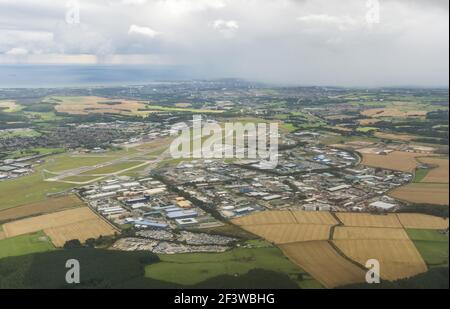 Luftaufnahme des Dyce Airport, Aberdeen, Schottland, Großbritannien, an einem bewölkten Tag. Blick nach Süden über die Start- und Landebahnen und Gebäude. Regen in der Ferne. Stockfoto