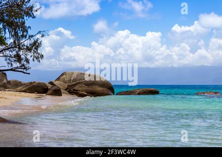 Wellen spritzen den Sand von Nudey Beach, Fitzroy Island, in den kristallklaren Gewässern des Korallenmeeres nahe der Küste von Queensland Australien. Stockfoto