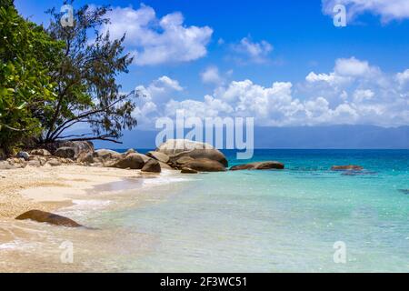 Wellen spritzen den Sand von Nudey Beach, Fitzroy Island, in den kristallklaren Gewässern des Korallenmeeres nahe der Küste von Queensland Australien. Stockfoto