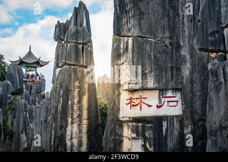 Szenische Ansicht der Kalksteinformation Panorama mit Shilin in roten chinesischen Schriftzeichen auf Shilin großen Stein Waldpark in Yunnan China (Übersetzung: Sto Stockfoto