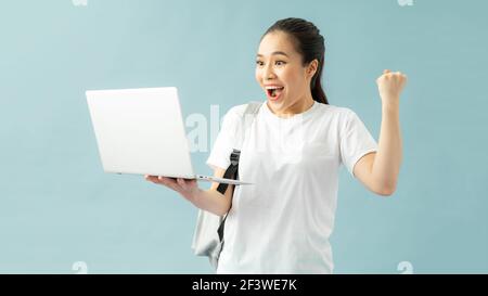 Schöne Studentin trägt einen Rucksack und mit Laptop schreien stolz und feiert Sieg und Erfolg sehr aufgeregt, jubelnde Emoticon Stockfoto